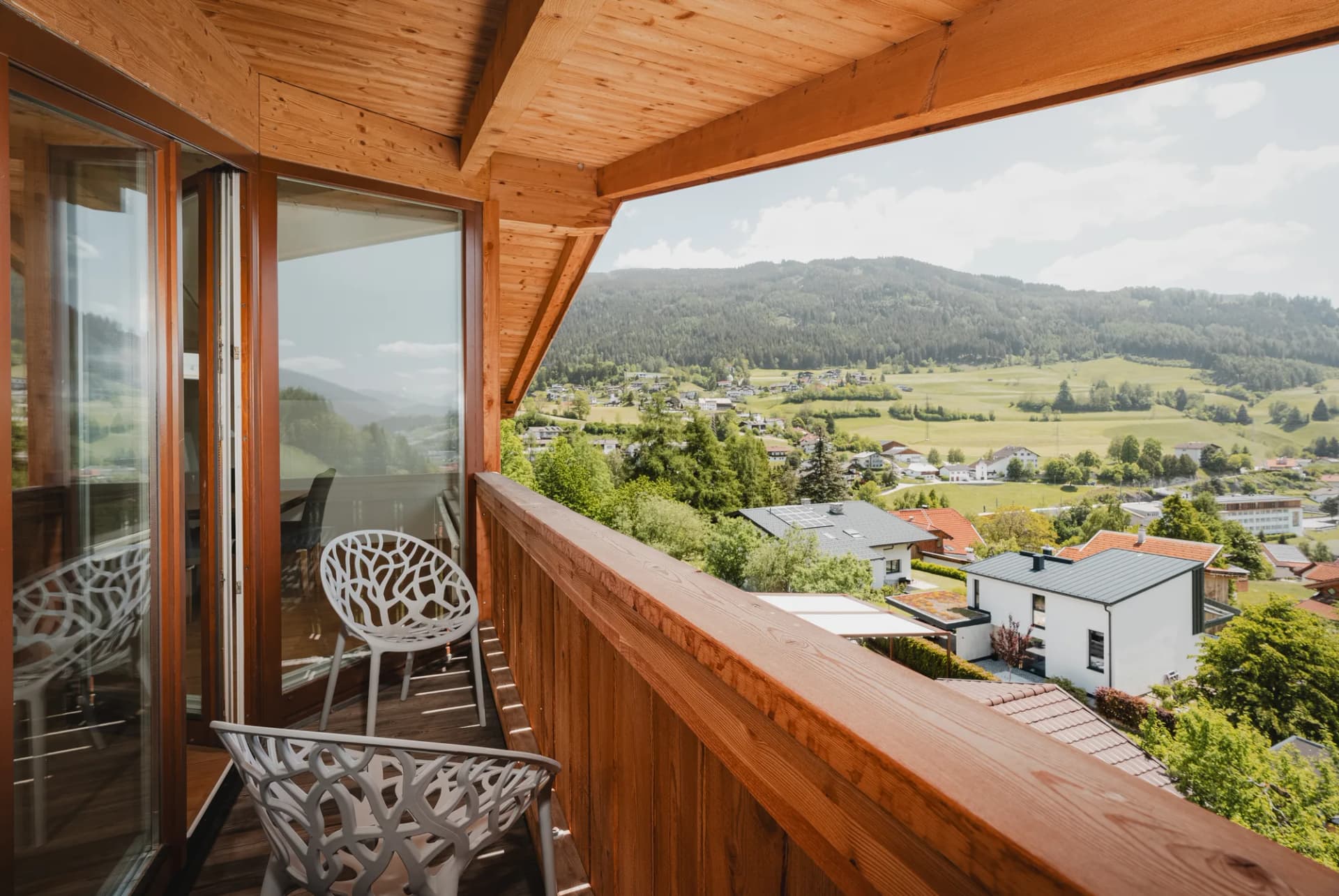 Panorama apartment Stoacherhof – balcony with wooden railing and designer chairs, overlooking the green Wipptal Valley | holiday flat Wipptal Tyrol